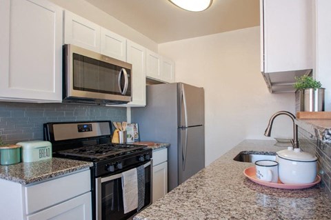 a kitchen with stainless steel appliances and granite counter tops
