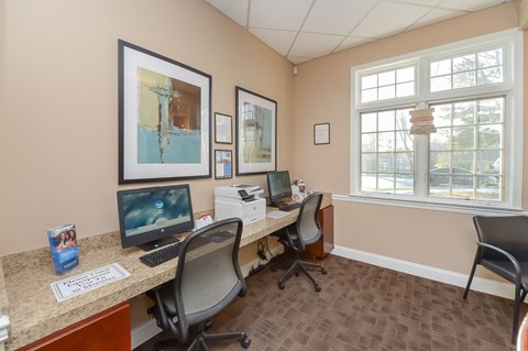 an office with two computers and a desk with chairs