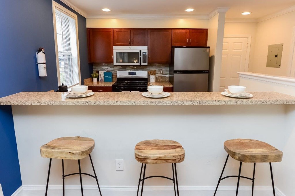 a kitchen with a counter top and three stools