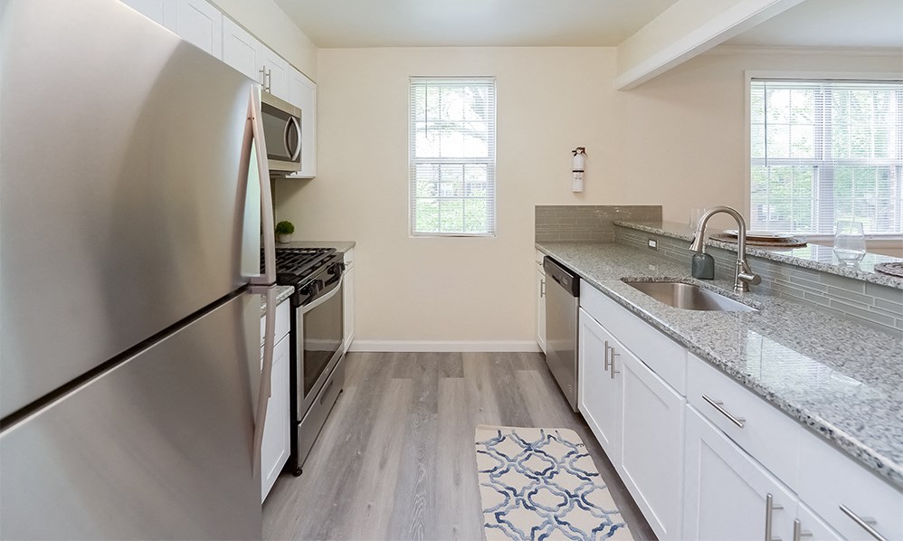 an empty kitchen with stainless steel appliances and granite counter tops