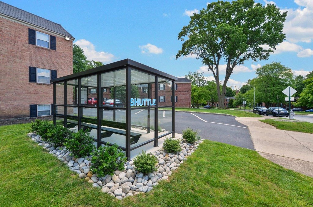 a glass building with a sign on the side of a street