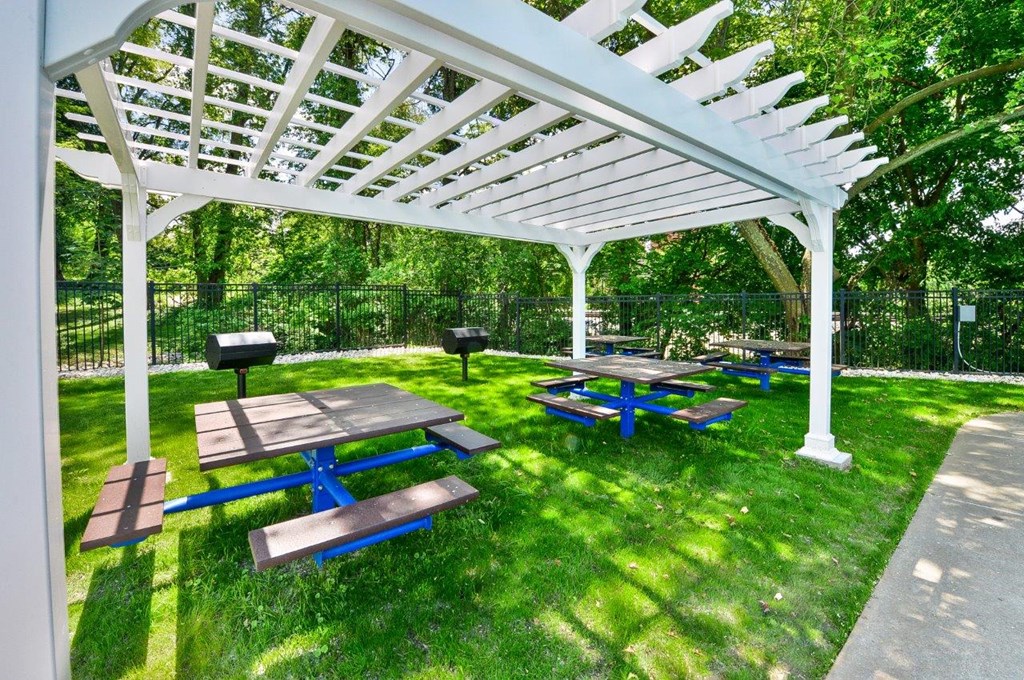 a picnic area with benches and a barbecue grill