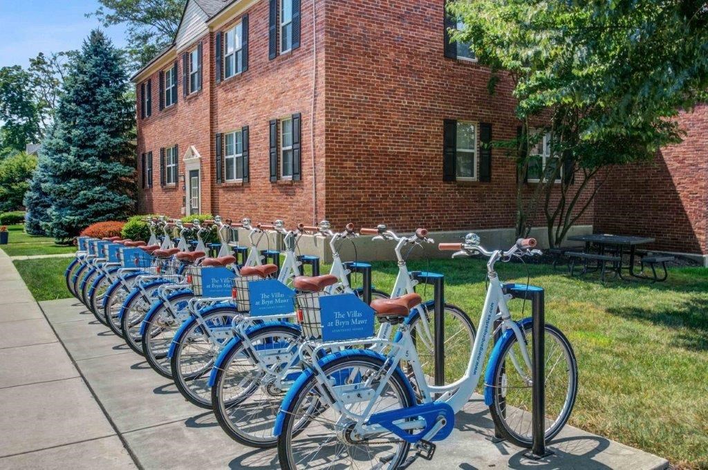 a row of blue bikes parked in front of a brick building