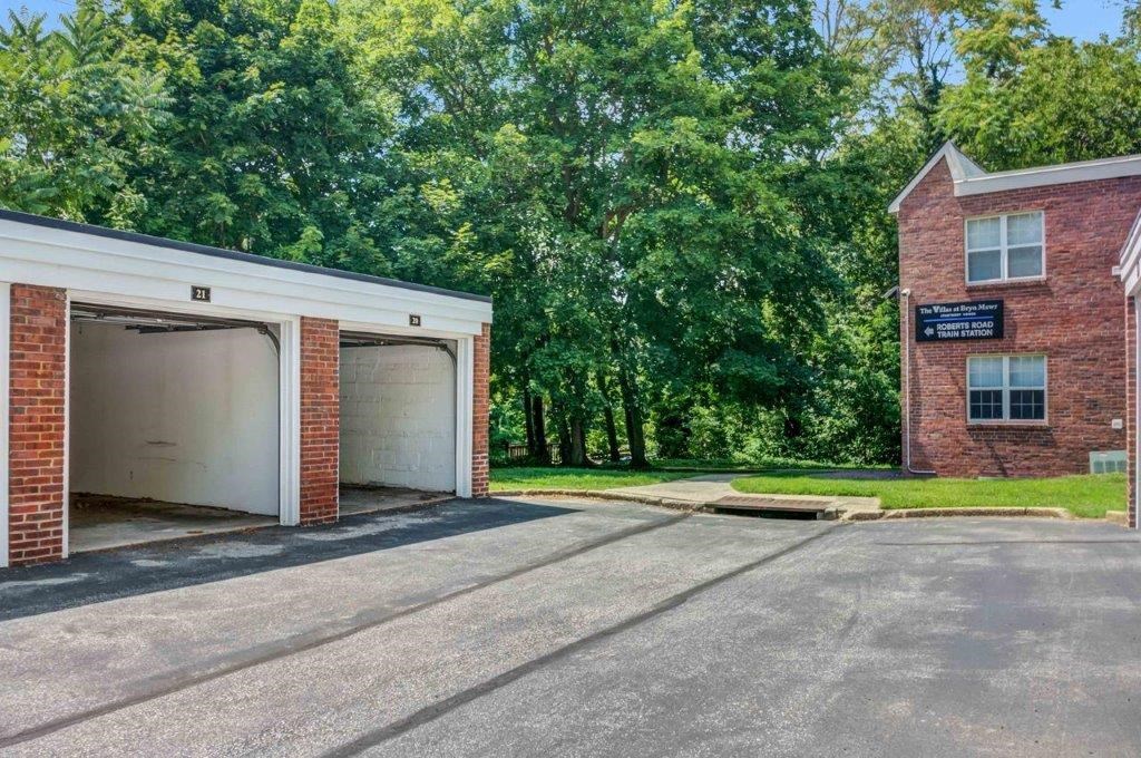 a brick building with two garages and a sign on the side