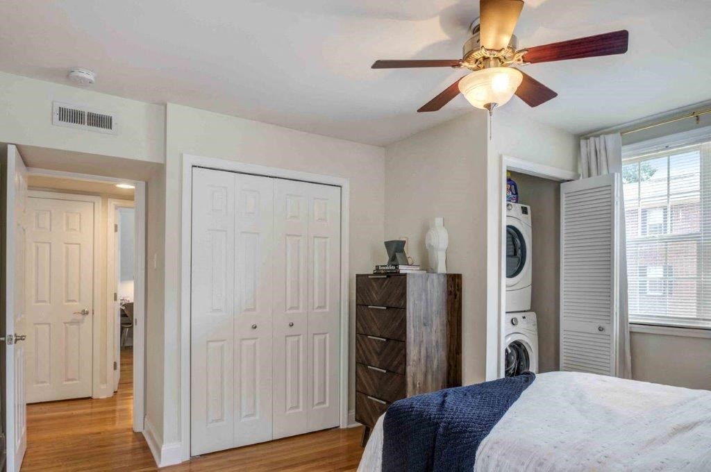 a bedroom with a bed and a ceiling fan and a washing machine