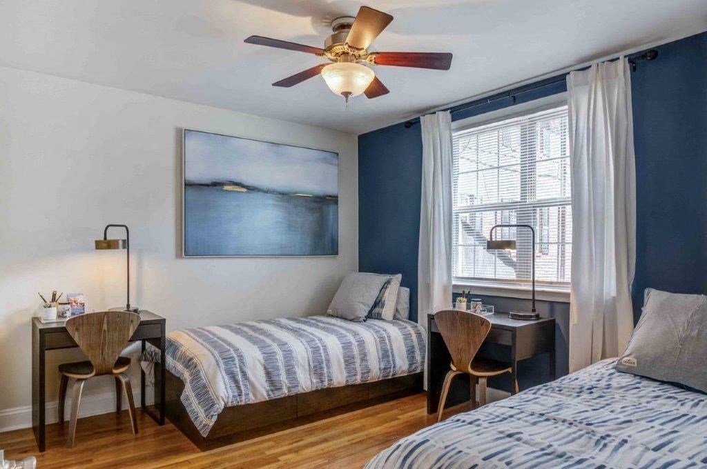 a bedroom with two beds and a ceiling fan