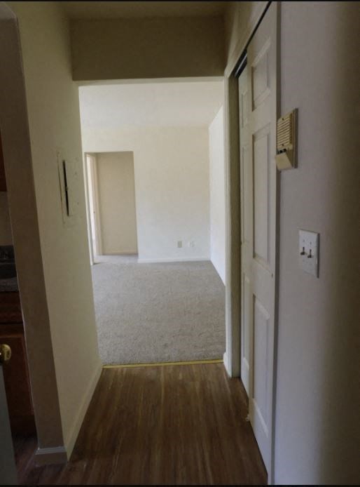 an empty room with a wooden floor and white walls