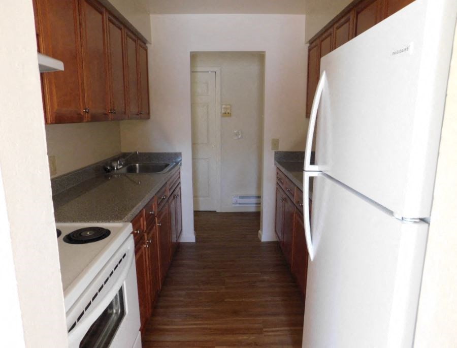 an empty kitchen with a refrigerator and a sink