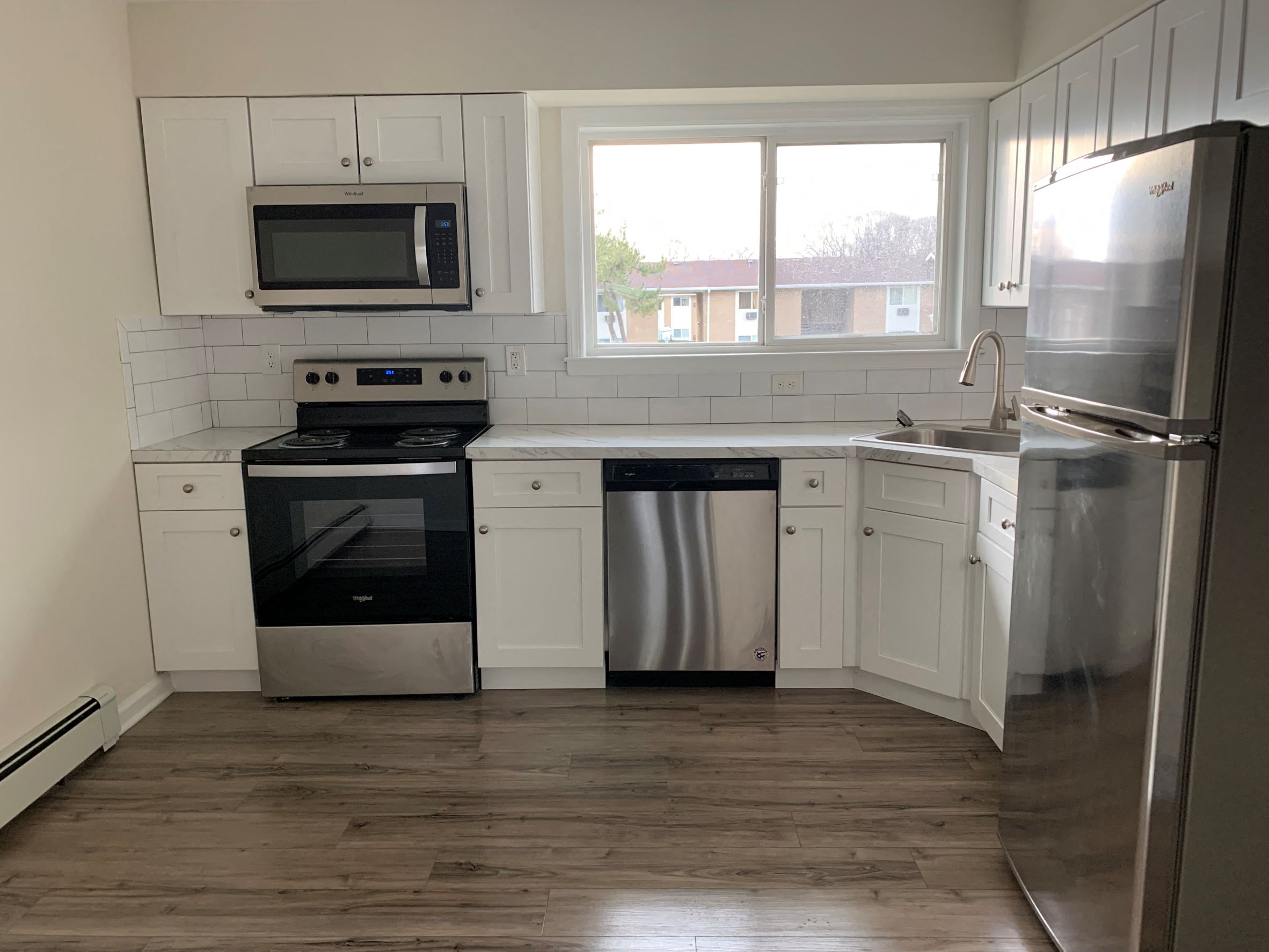 a kitchen with white cabinets and stainless steel appliances