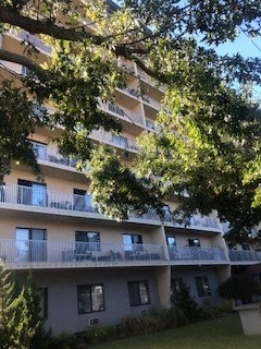an apartment building with a tree in front of it