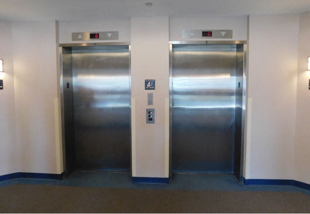 two stainless steel elevators in a lobby of a building