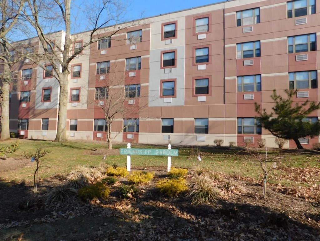 a green bench in front of an apartment building