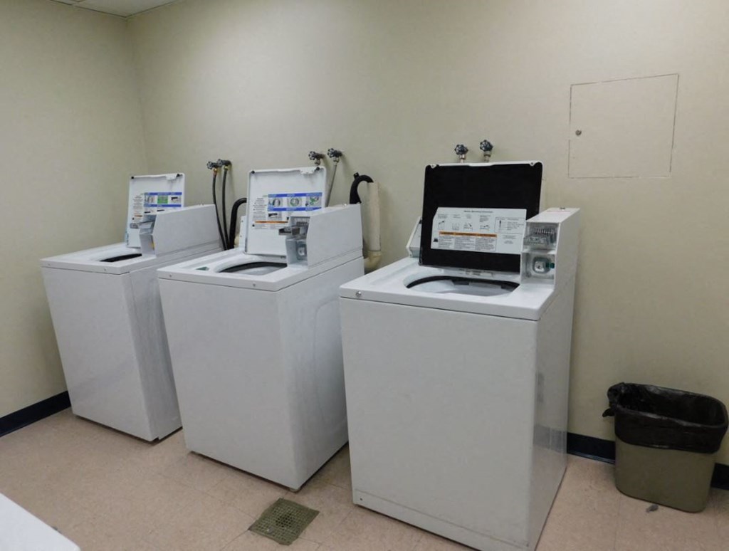 four washing machines are lined up next to each other