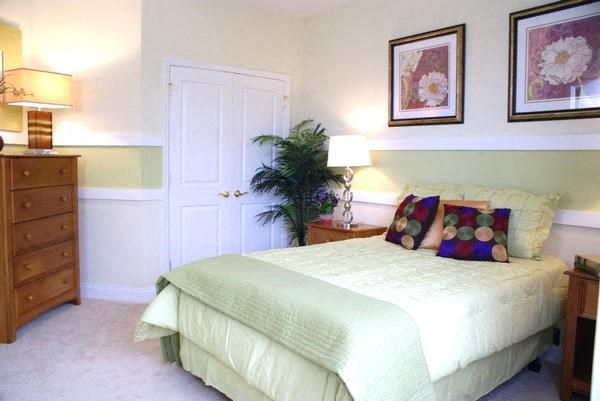 a white bedroom with a bed and two lamps