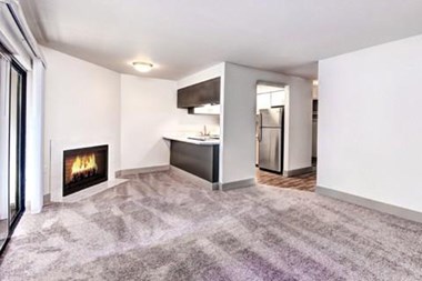 Milton Apartments - Autumn Village Apartments - Living Room, Fireplace, Kitchen, and Deck
