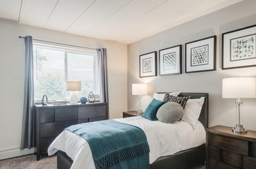 a bedroom with a bed and some pictures on the wall