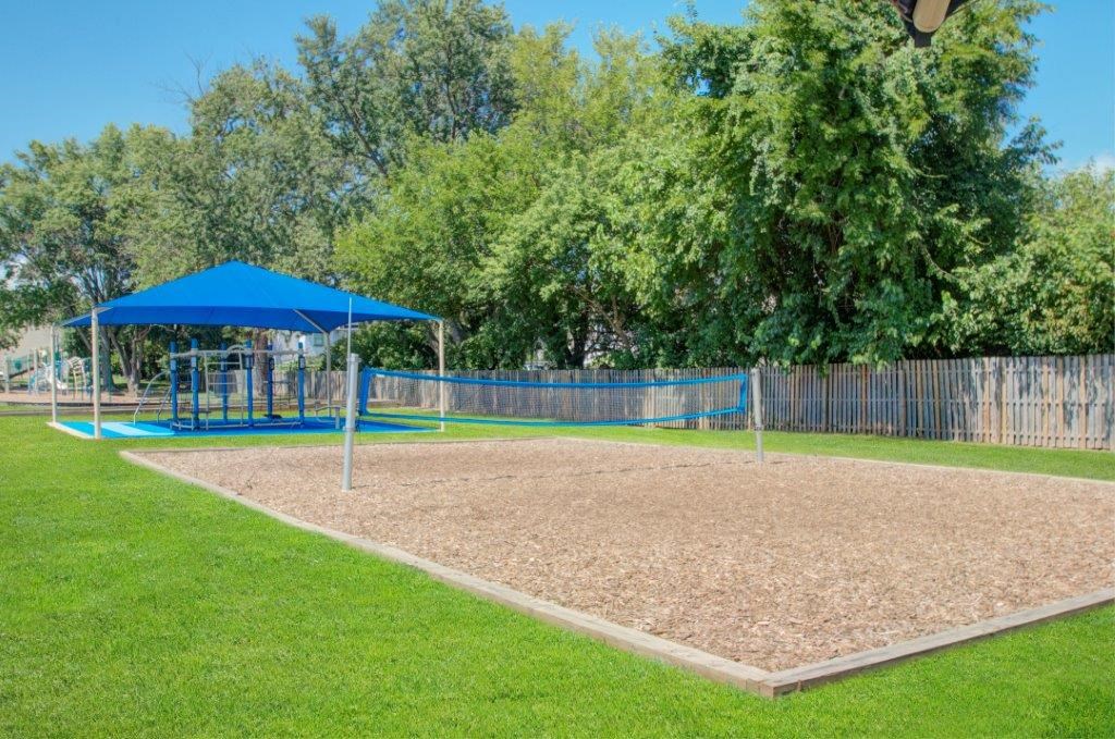 a fenced in playground with a blue swing set