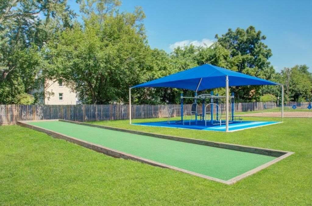a playground with a blue canopy and a blue swing set