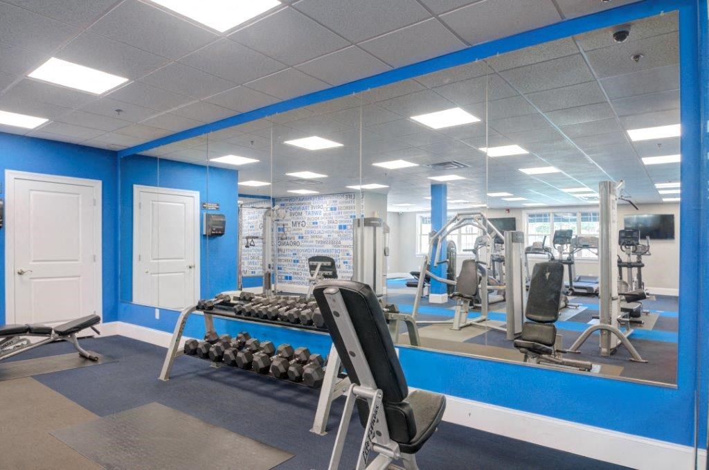 a gym with weights and other equipment in a building with blue walls