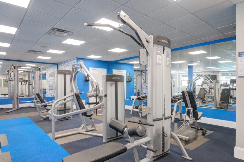 a gym with weights and other equipment in a building with blue walls