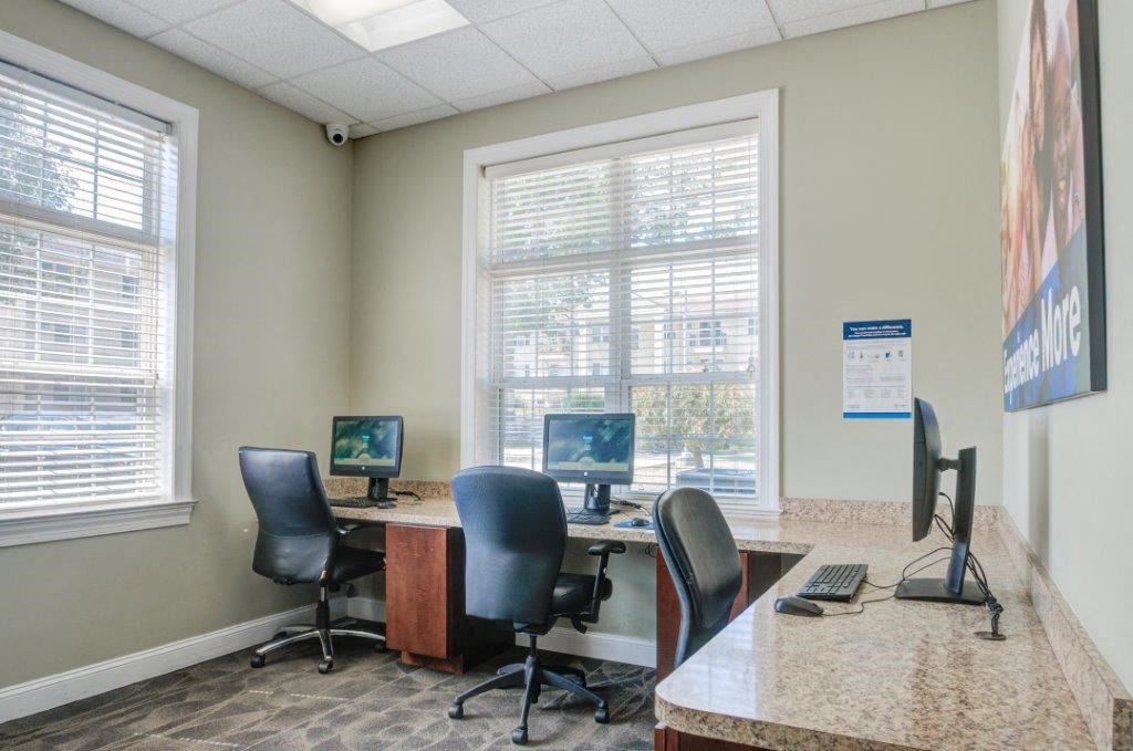a office with two computers and a table with chairs