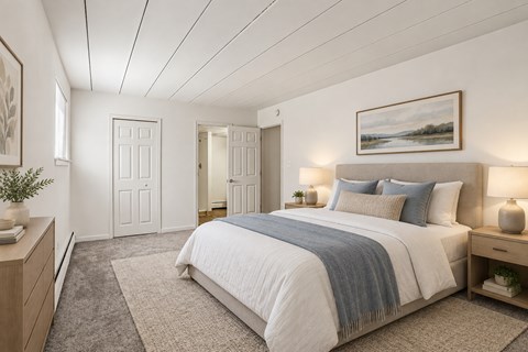 A bedroom with a large bed and a painting on the wall.