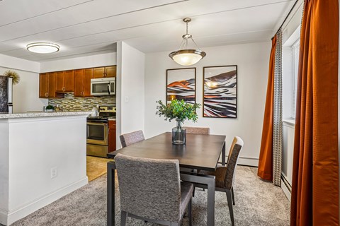 A dining room with a table and chairs.