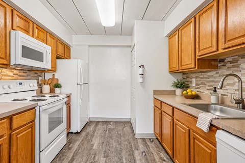 A kitchen with wooden cabinets and white appliances.