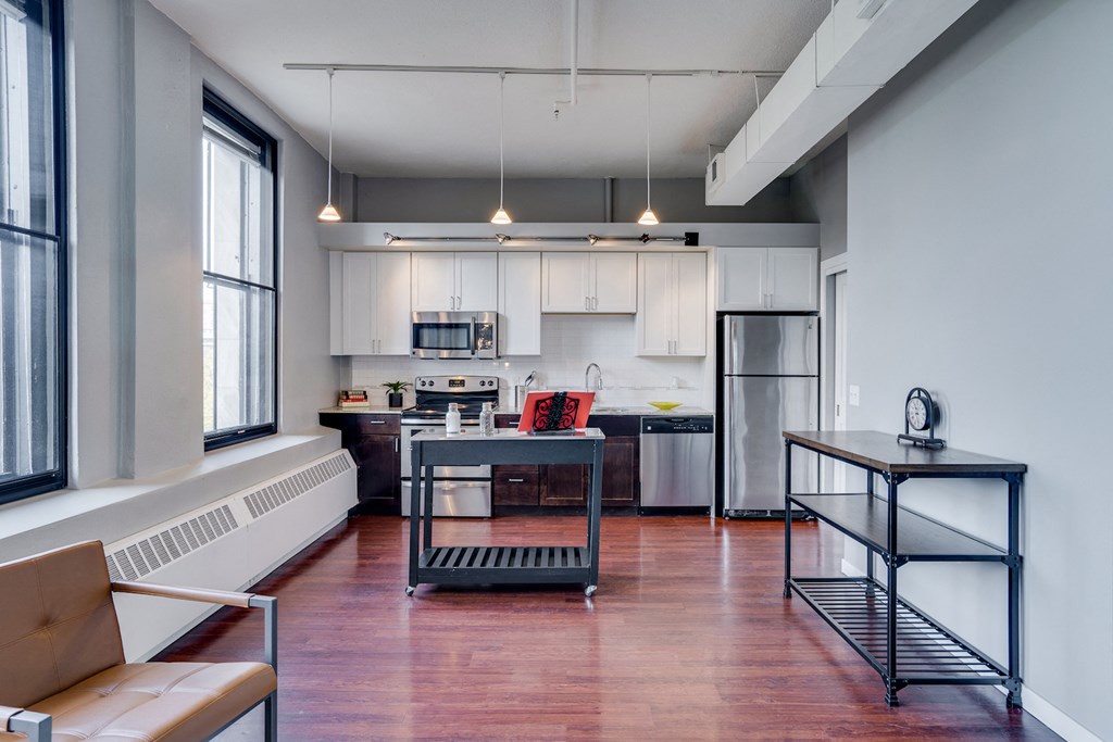 an open kitchen and living room with a black island in the middle