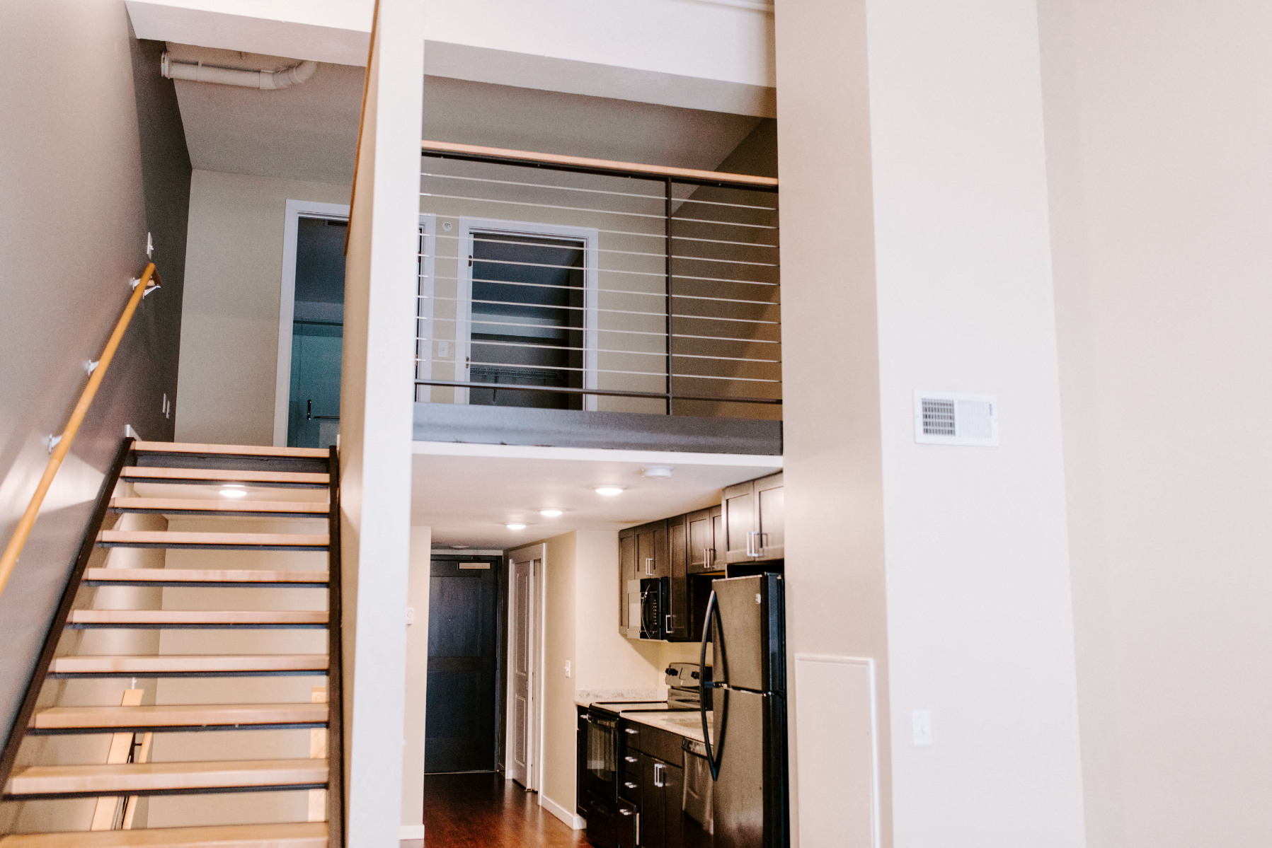 a view of a staircase and a kitchen from a living room
