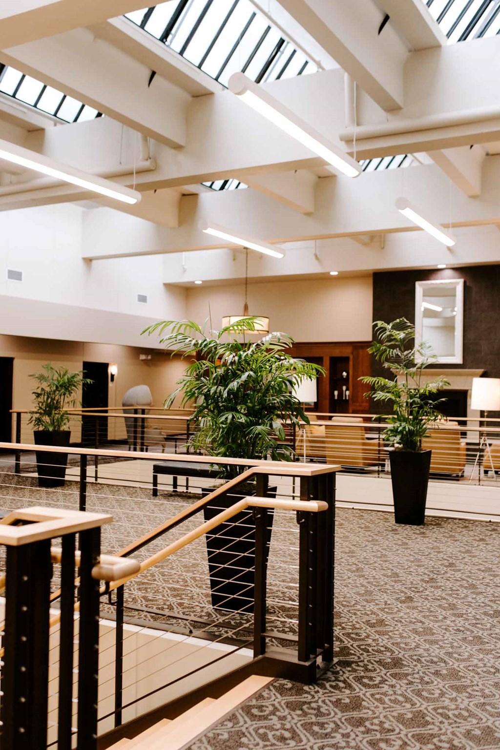 a view of the lobby of a building with benches and plants