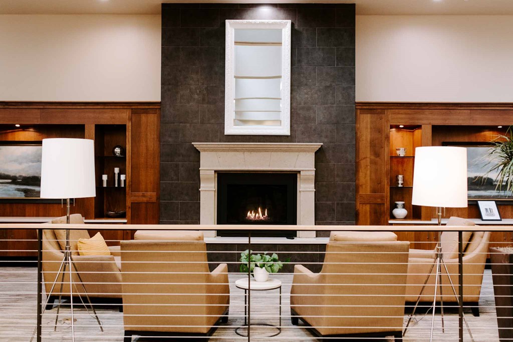 a lobby with a fireplace and a table with chairs
