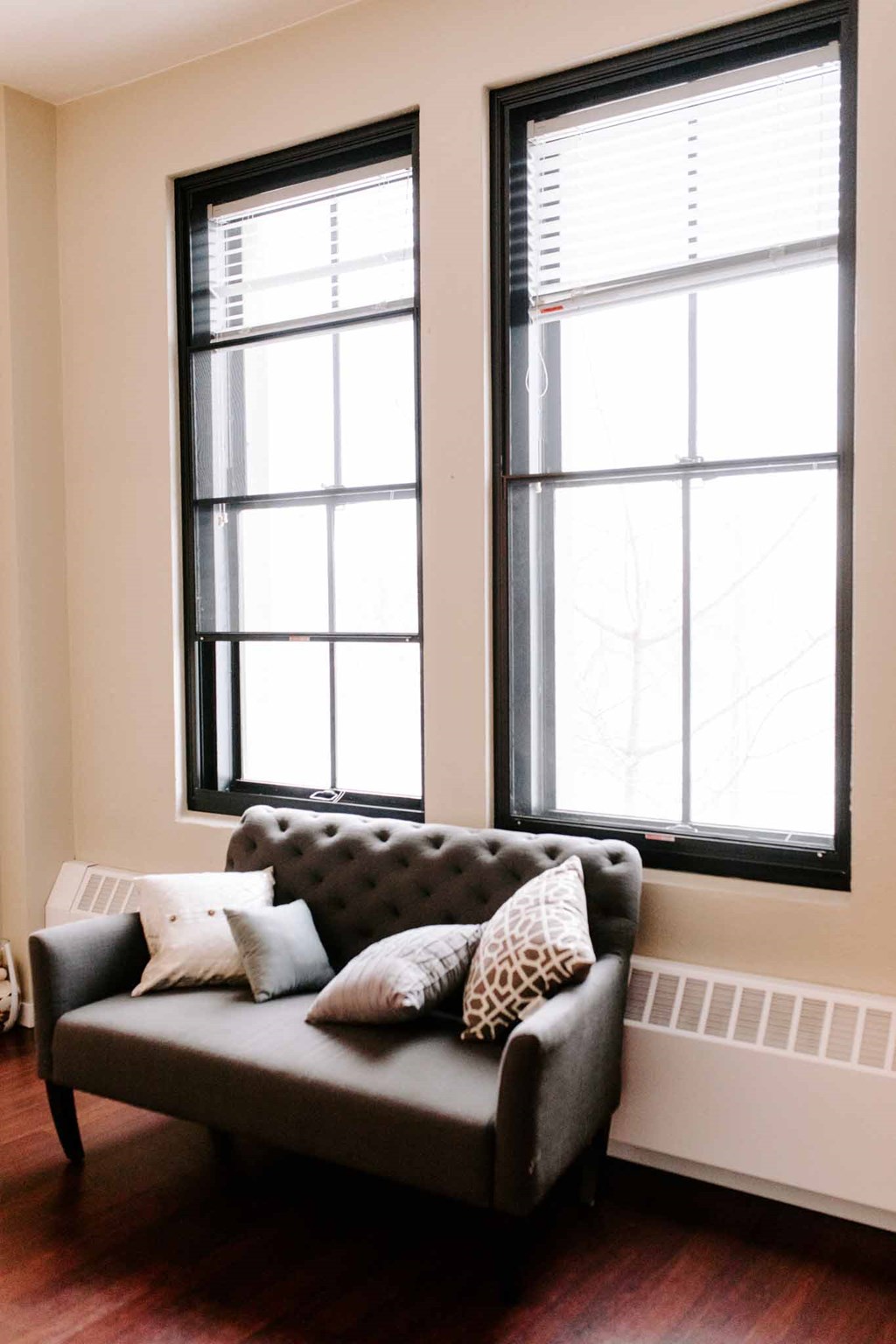 a couch in front of two windows in a living room
