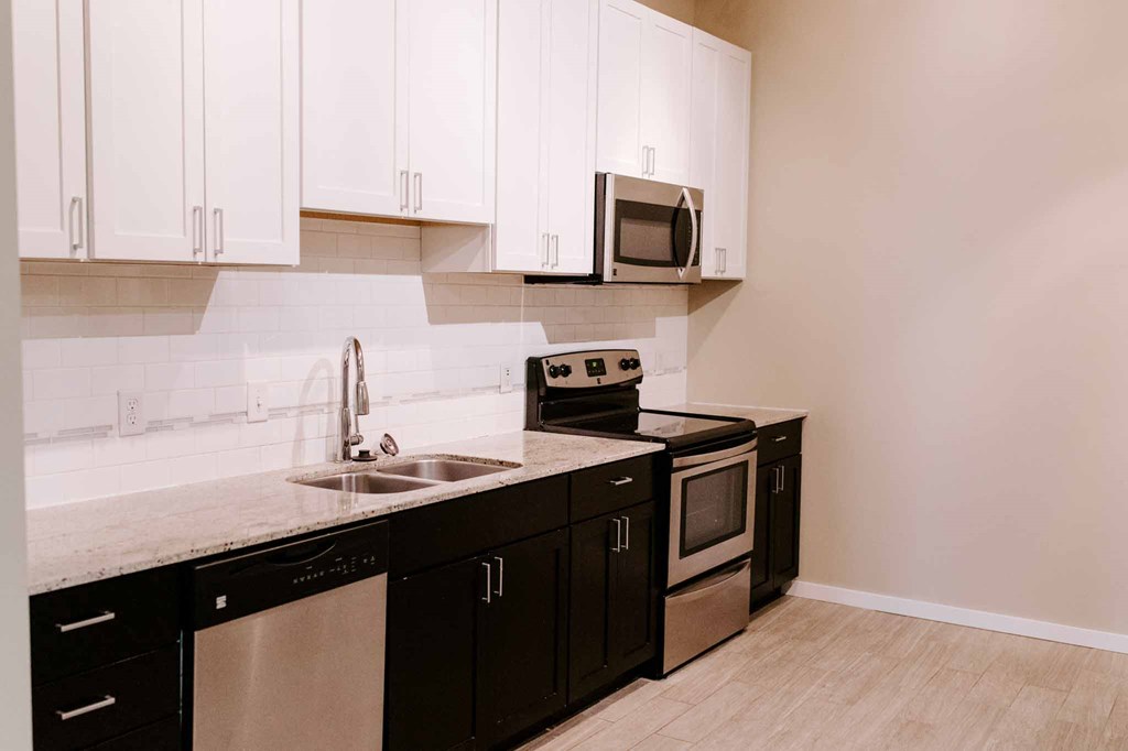 a kitchen with black and white cabinets and a sink