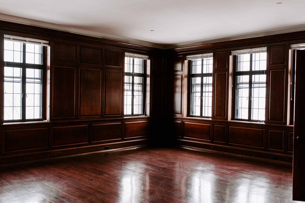 an empty room with wooden floors and windows