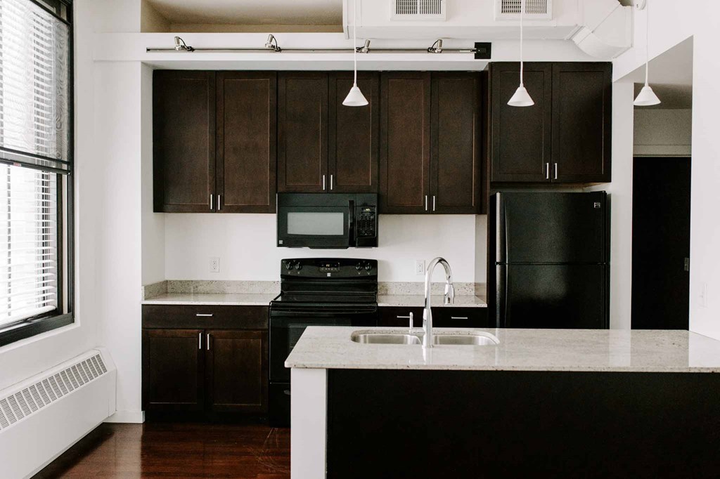 a kitchen with black appliances and white counter tops
