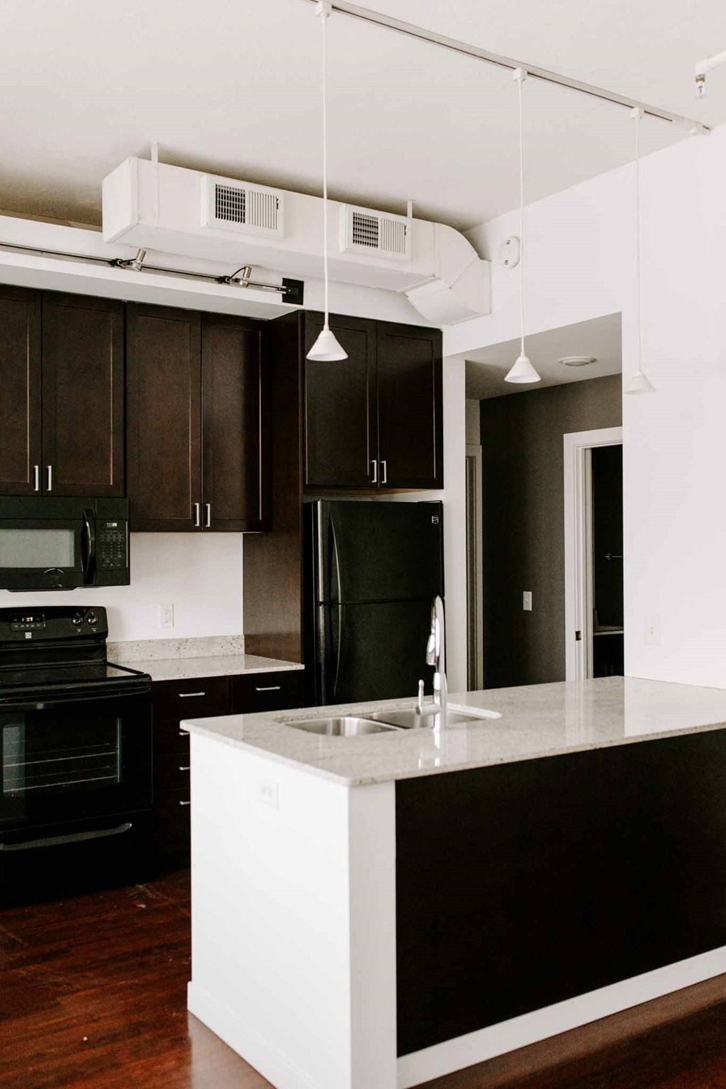 a white kitchen with black cabinets and a black stove