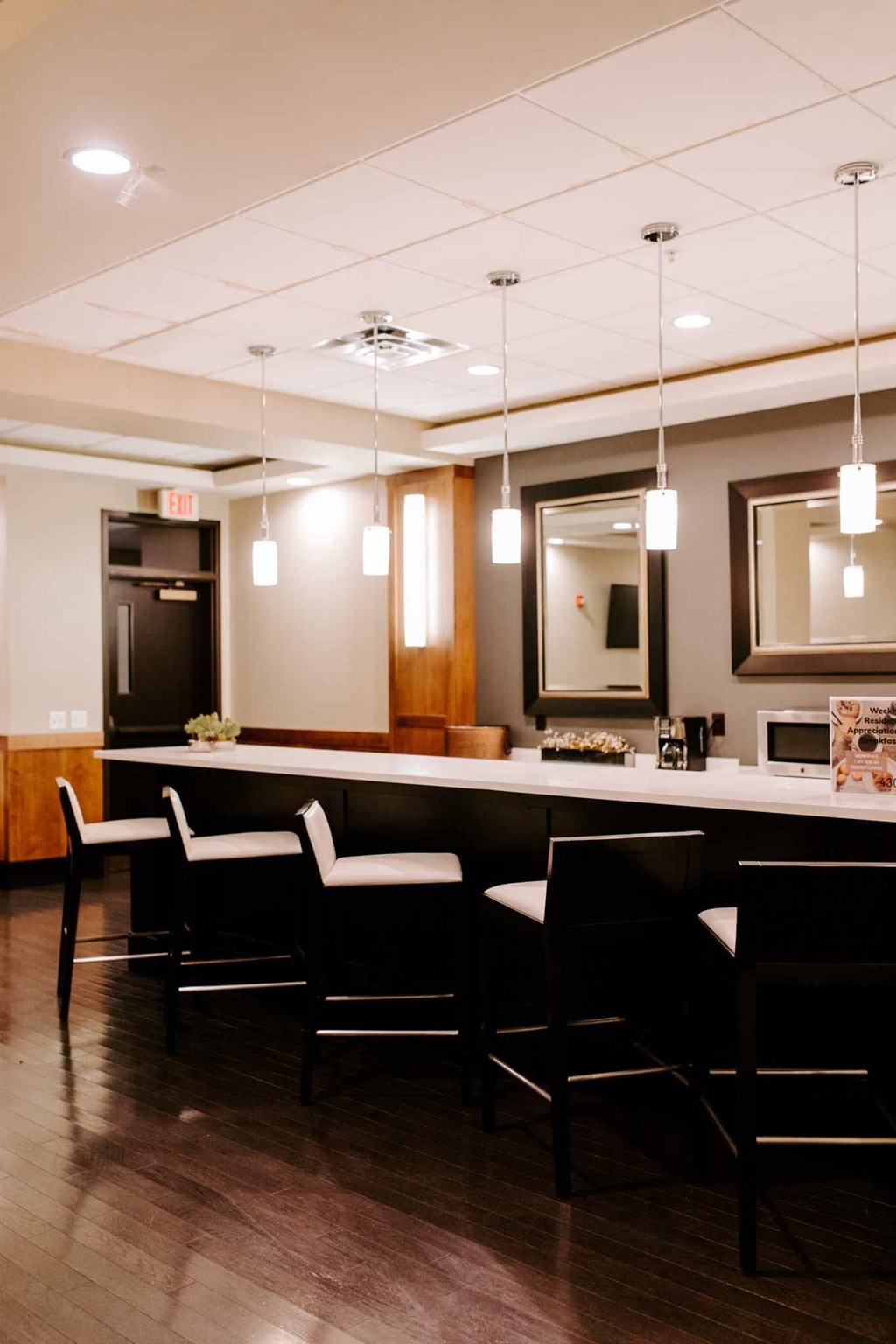 a bar in a room with chairs and a counter