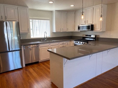 a kitchen with stainless steel appliances and white cabinets
