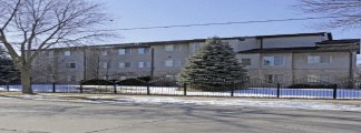 A large building with a fence and a tree in front of it.