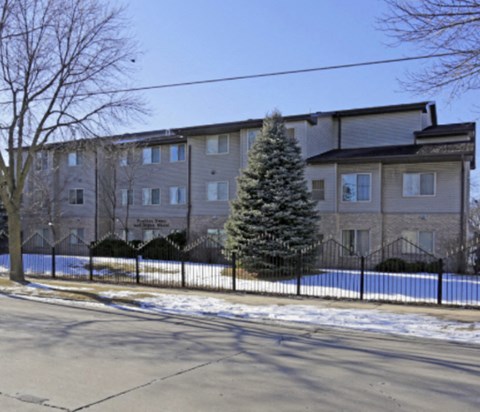 A large apartment building with a Christmas tree in front.