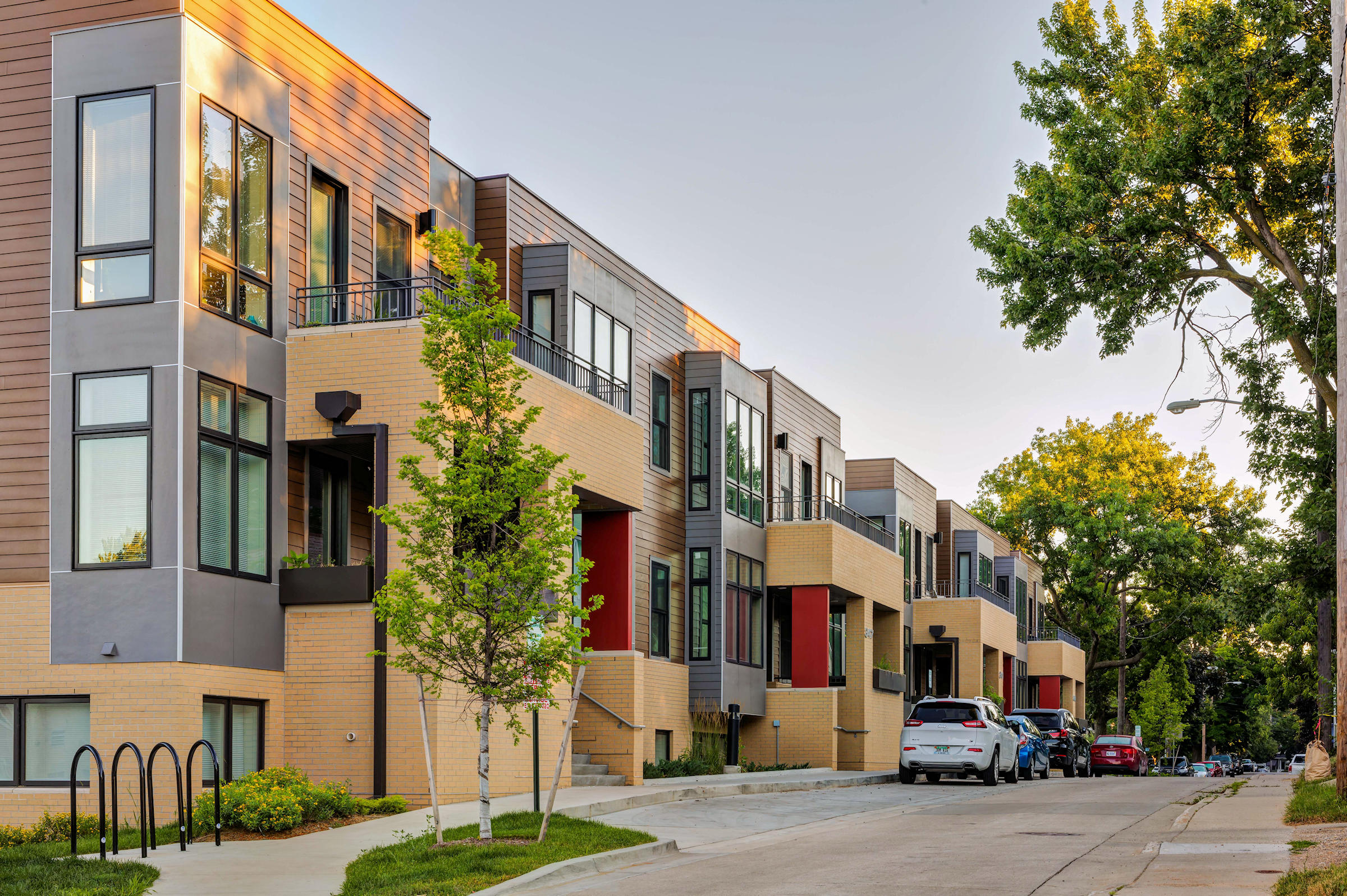 a row of houses with cars parked in front of them