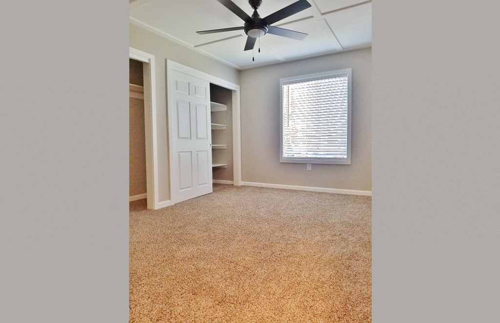 Bedroom view with carpet flooring, well lit window, ceiling fan, and closet with built in shelfing