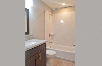 bathroom Bathroom view with vanity, toilet, and tub shower combo - Photo Gallery