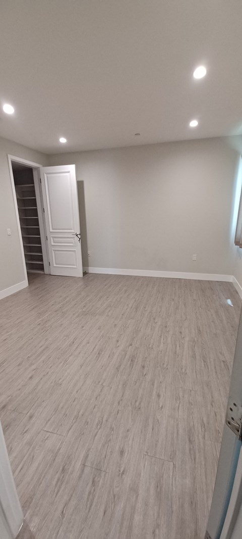 a living room with a hard wood floor and white walls