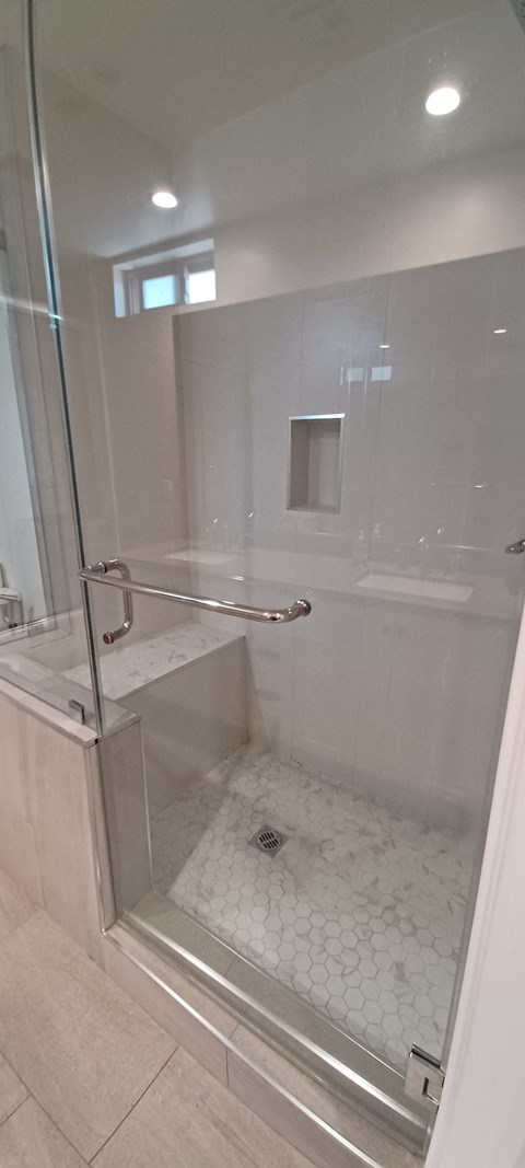 a large shower with a glass door in a bathroom