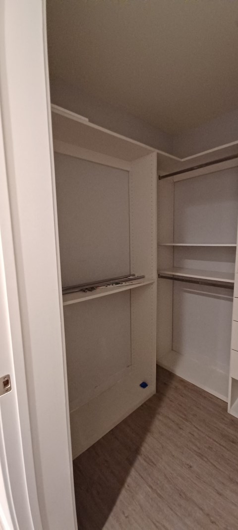 a walk in closet with shelves and a blue ball on the floor