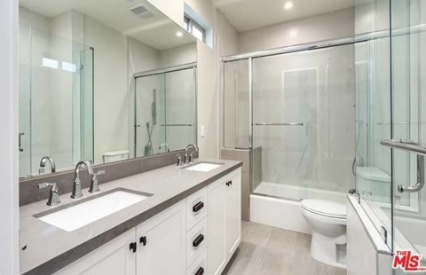 a bathroom with two sinks and a shower and a toilet