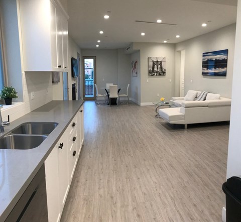 an open living room and kitchen with a hard wood floor