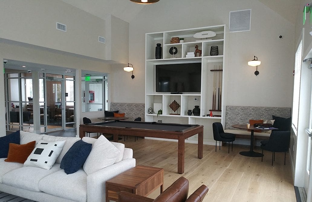 A living room with a white couch and a wooden coffee table.